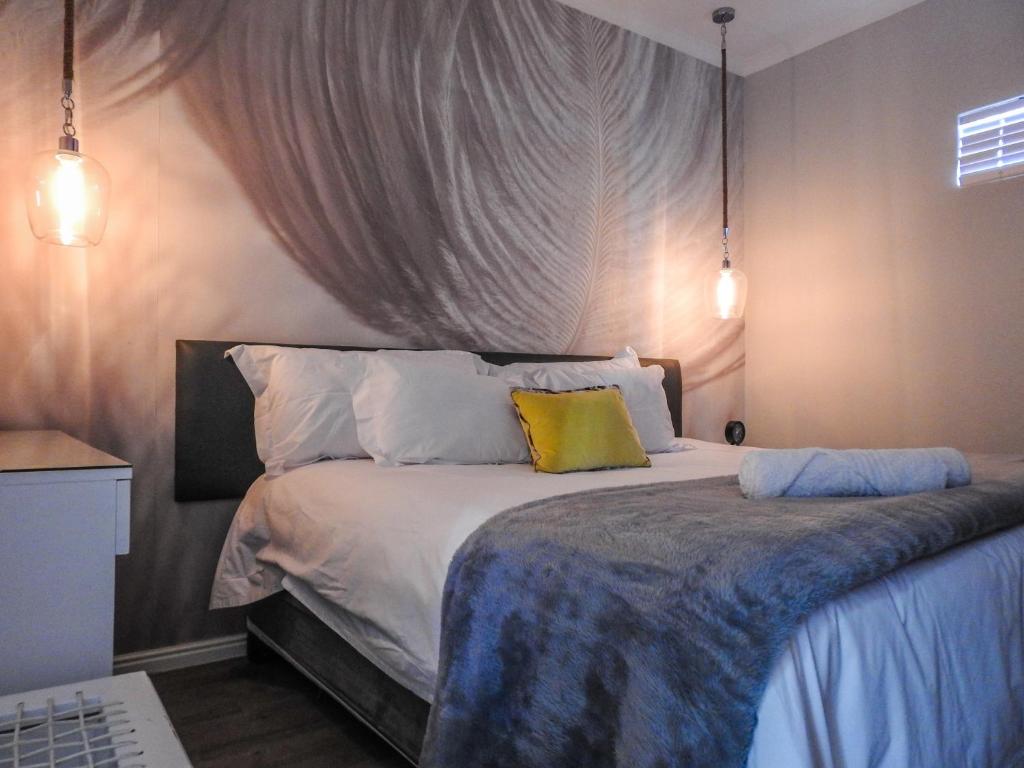 a bedroom with a bed with three pillows at The Featherbed - Oudtshoorn in Oudtshoorn