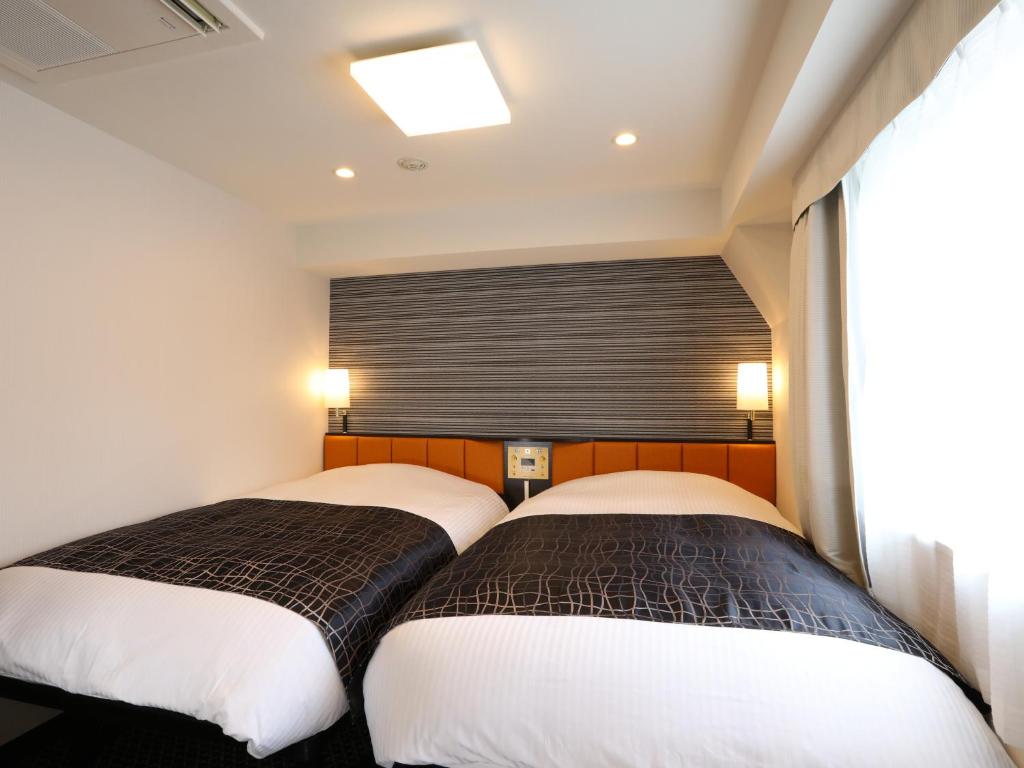 Postel nebo postele na pokoji v ubytování APA Hotel Shinjuku Kabukicho Chuo
