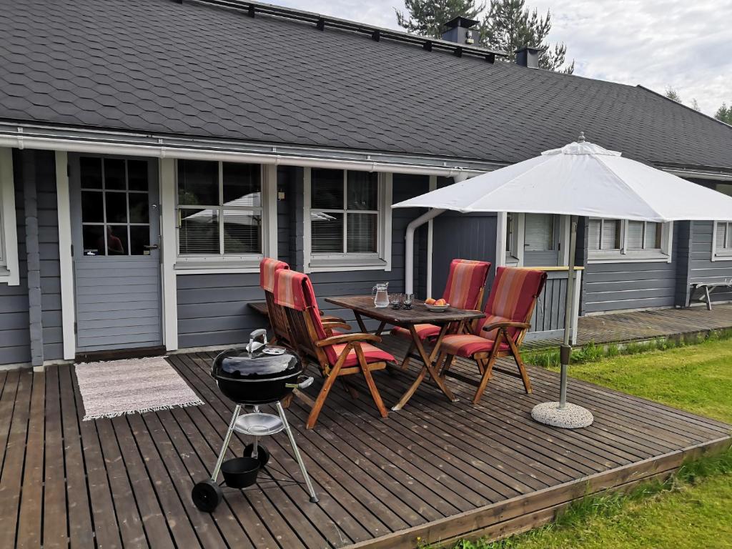 a patio with a table and chairs and an umbrella at Aaria Apartment in Tahkovuori