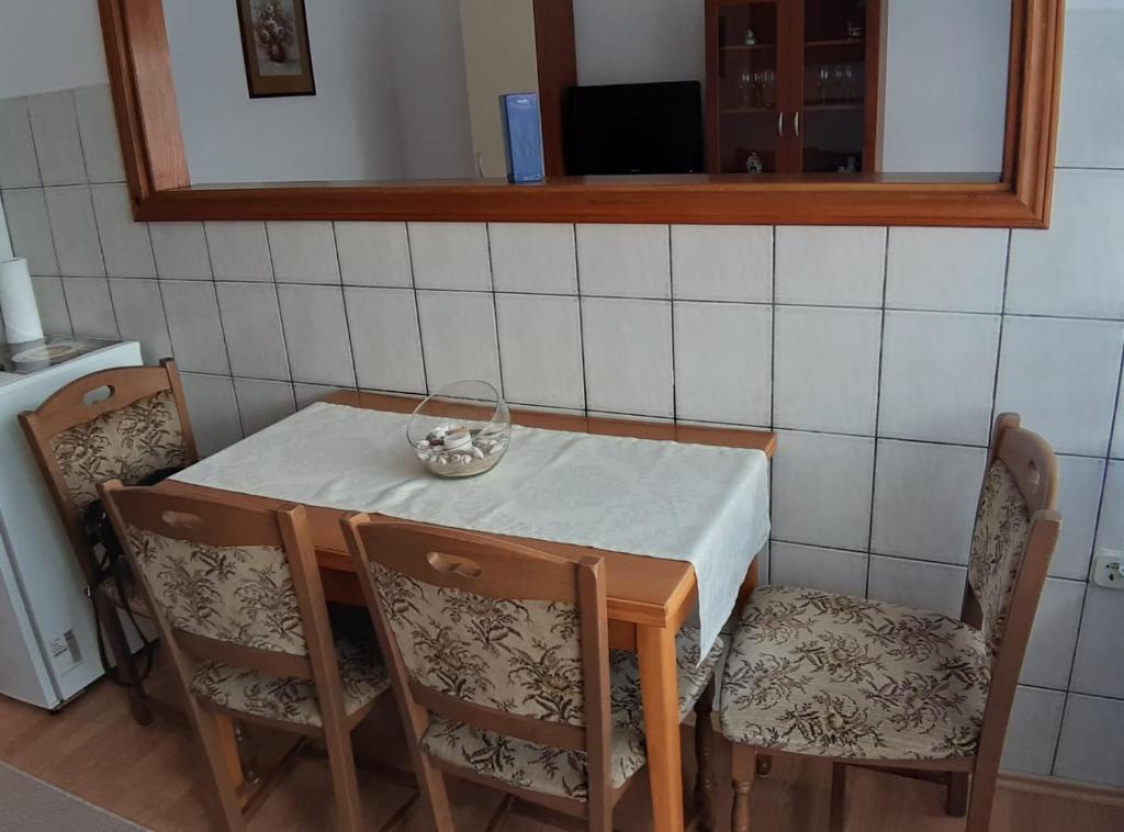 a dining room table with two chairs and a bowl on it at Apartment Ivana in Gospić