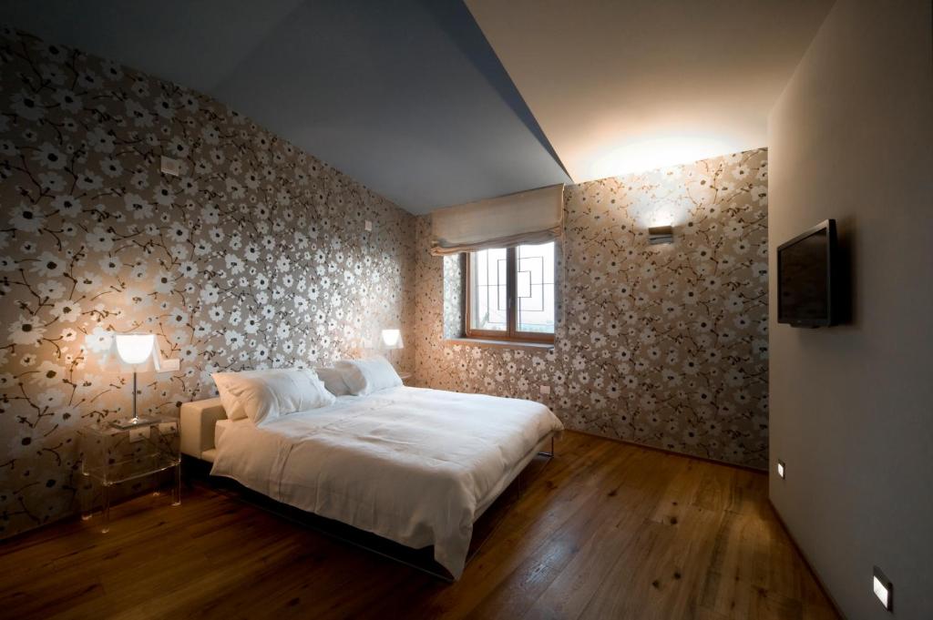 Un dormitorio con una gran cama blanca y una pared en Le Civette, en Morro dʼAlba
