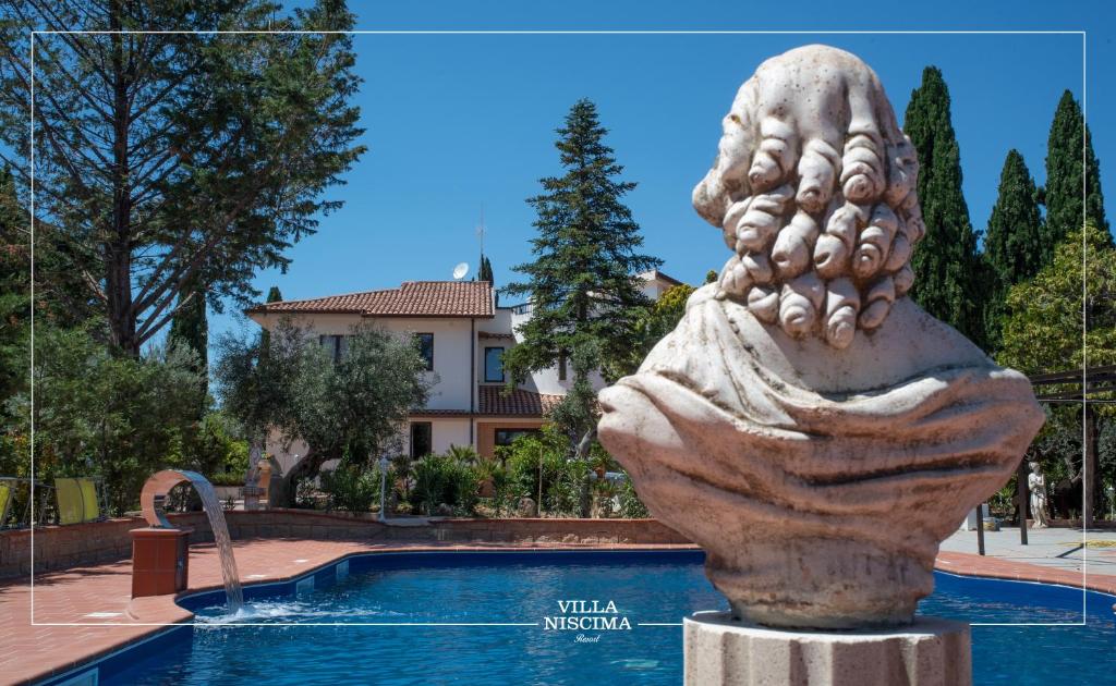 una estatua frente a una piscina en Villa Niscima, en Caltanissetta