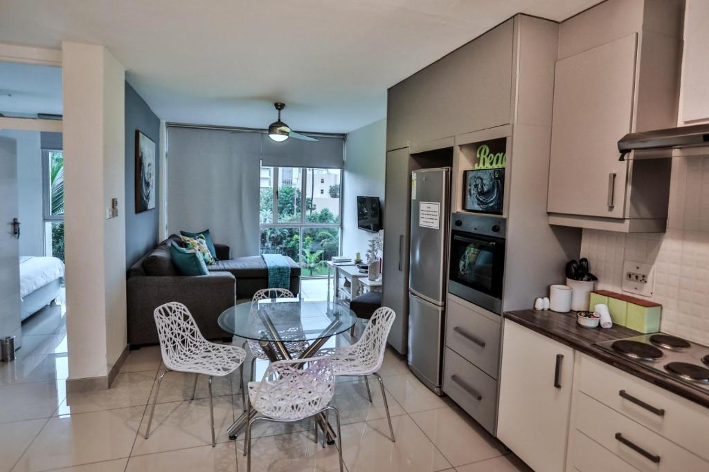 a kitchen and living room with a table and chairs at 207 La Ballito-Luxury Family apartment in Ballito