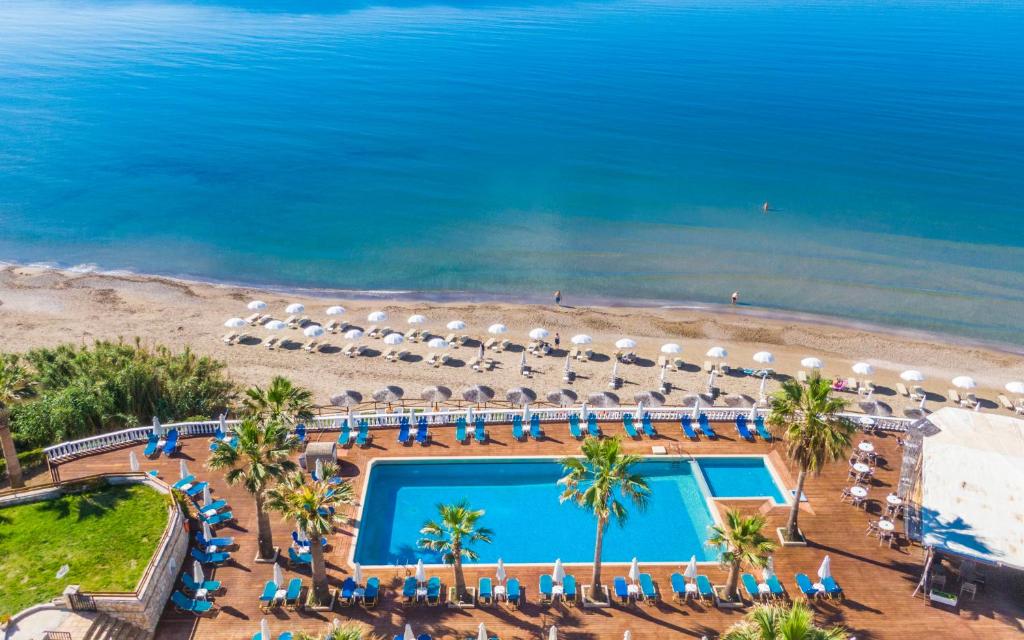 een luchtzicht op een resort met een zwembad en het strand bij Crystal Beach Hotel in Kalamaki