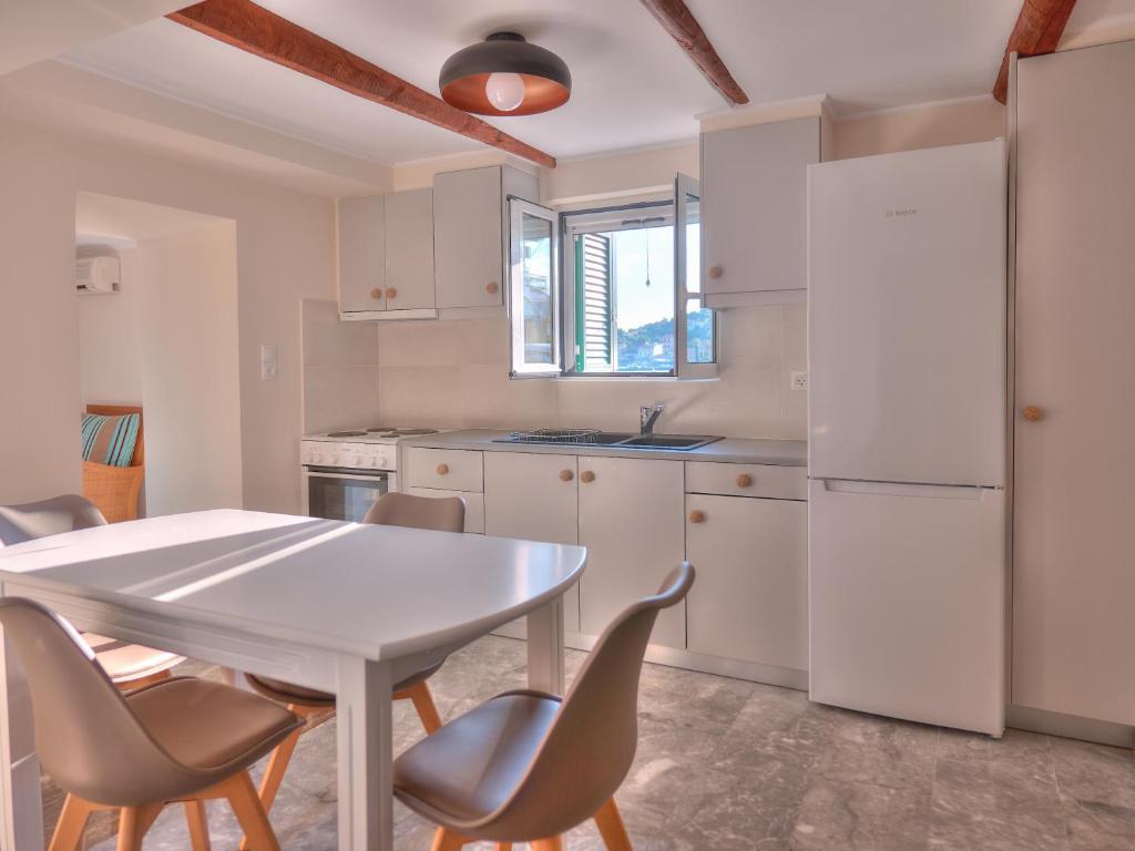 eine Küche mit einem weißen Tisch und Stühlen in der Unterkunft Alexis Studios in Finikounda