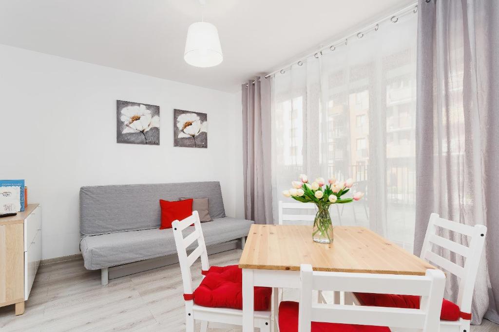a living room with a table and chairs and a couch at Apartments Claro II by Renters in Krakow