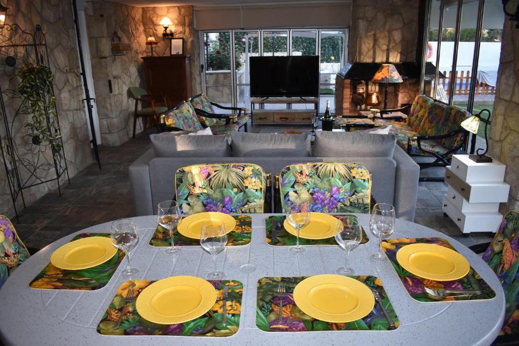 un tavolo bianco con piatti e bicchieri gialli di VILLA GARDEN a Tarragona