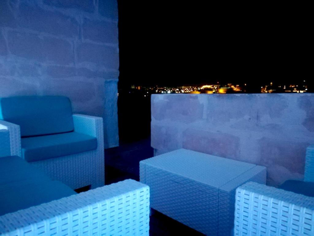 a room with chairs and a view of a city at night at Kharmen A 1565s House with Seaviews in Birgu