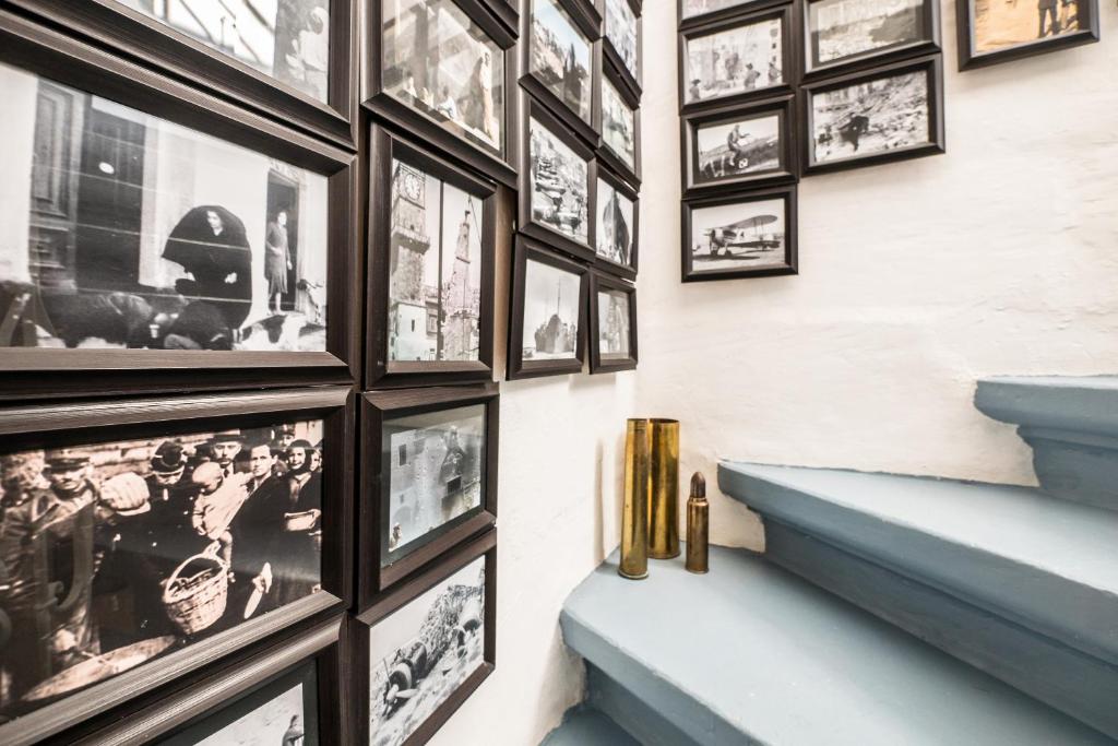 a hallway with pictures on the wall and blue stairs at Kharmen A 1565s House with Seaviews in Birgu