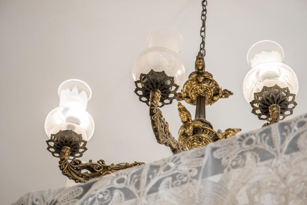 a chandelier with four lights on a wall at Kharmen A 1565s House with Seaviews in Birgu