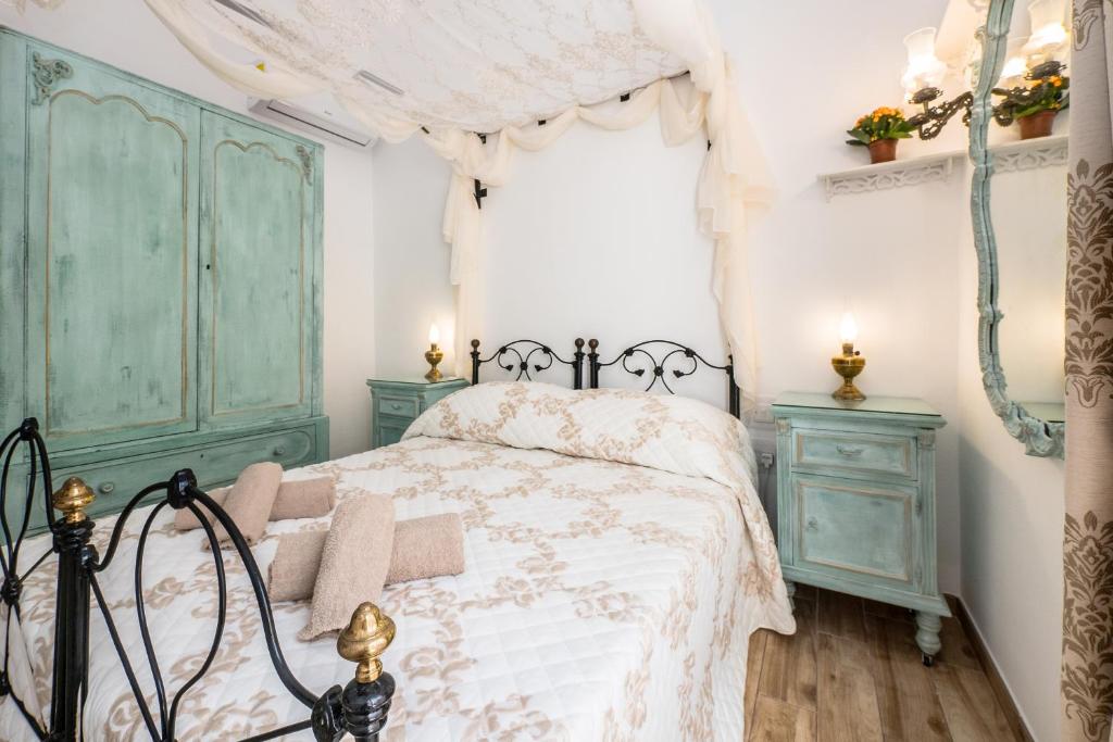 a bedroom with a green and white bed and a window at Kharmen A 1565s House with Seaviews in Birgu