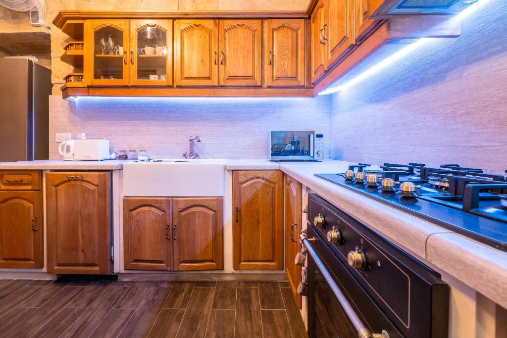 a kitchen with wooden cabinets and a counter top at Kharmen A 1565s House with Seaviews in Birgu