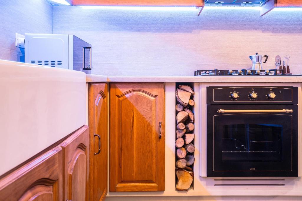 a kitchen with a stove and a oven with logs at Kharmen A 1565s House with Seaviews in Birgu