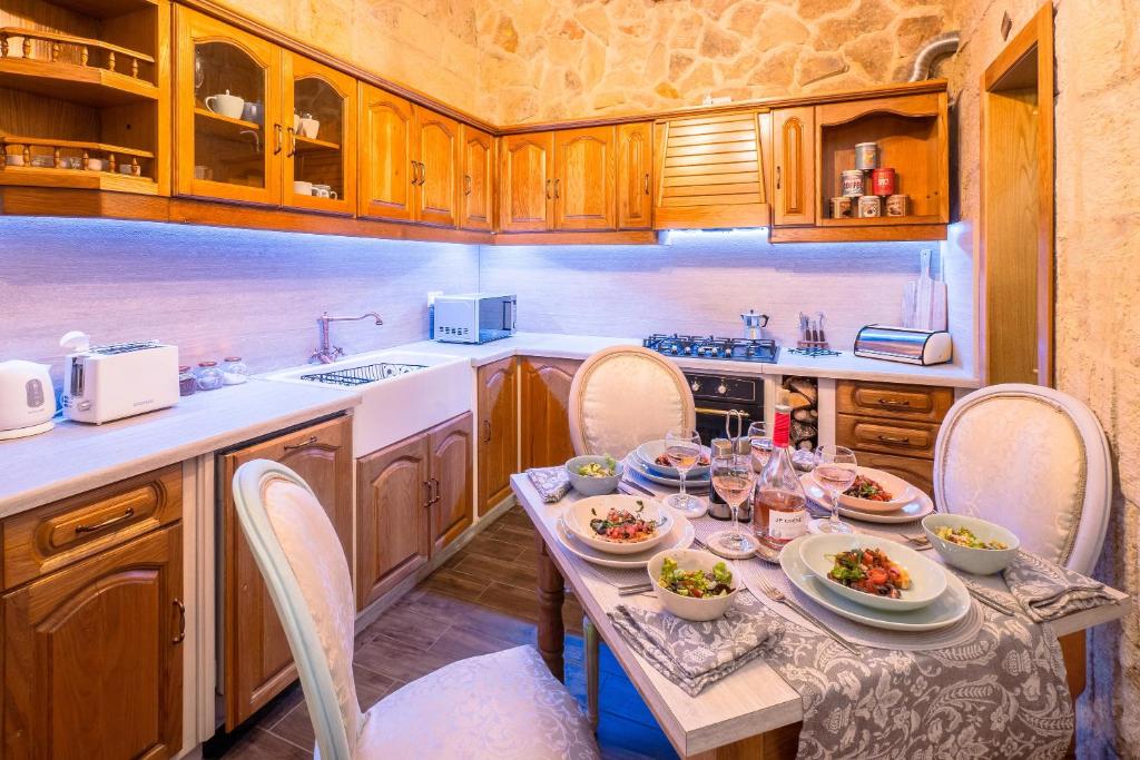a kitchen with a table with plates of food on it at Kharmen A 1565s House with Seaviews in Birgu