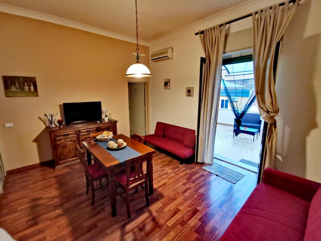 un soggiorno con tavolo e divano rosso di Little Home a Catania