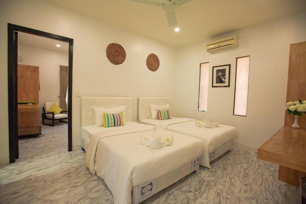 een hotelkamer met 2 bedden en een spiegel bij Bamboo9 Boutique in Phnom Penh