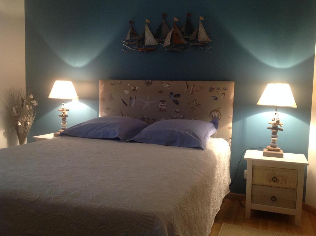 - une chambre avec un grand lit et deux lampes dans l'établissement Chambres d'hôtes dans la baie du Mt St Michel, à Carolles