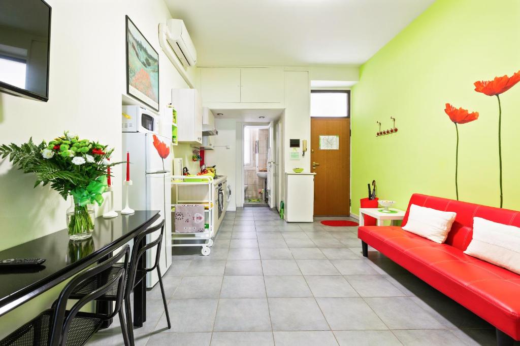 salon z czerwoną kanapą i kuchnią w obiekcie Cenisio & Sempione Cosy Flat w Mediolanie