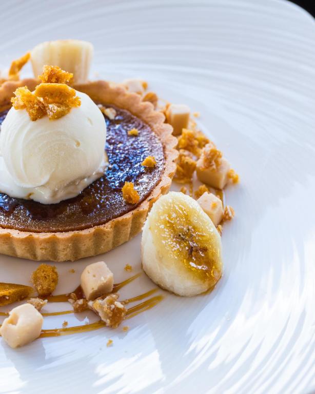 a white plate with a pie with ice cream on it at The Randolph Hotel in Southwold