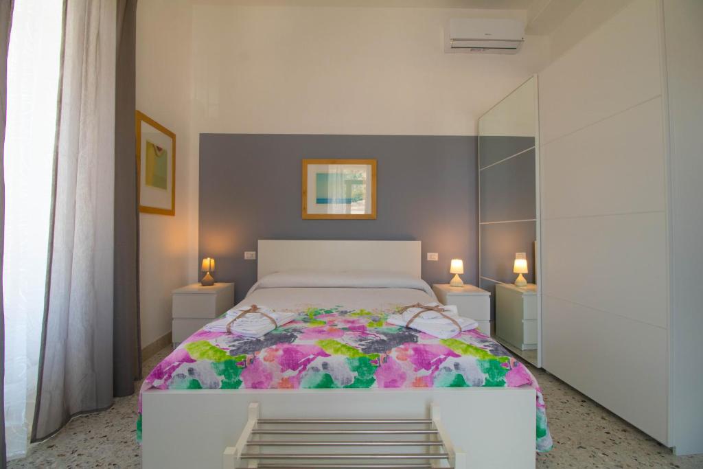 Casa Vacanze Belvedere في شيكلي: غرفة نوم مع سرير كبير مع بطانية ملونة