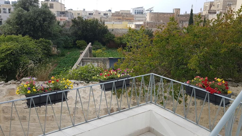 Una escalera con flores en macetas. en Dar is-Sliem, en Tarxien
