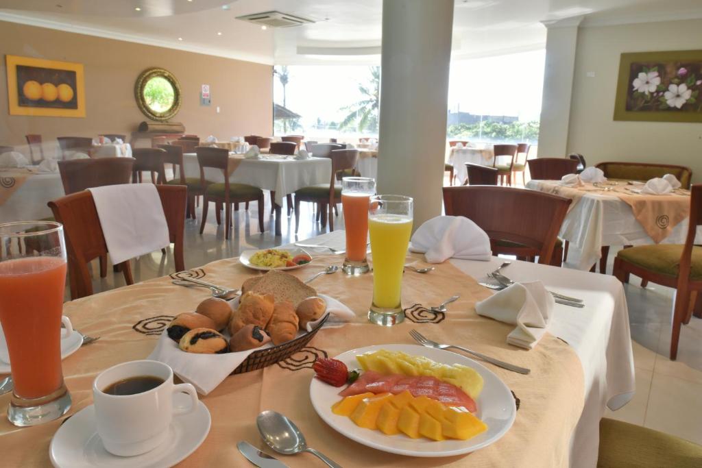 una mesa con un plato de comida y bebidas. en Gran Hotel De Lago - El Coca, en Puerto Francisco de Orellana