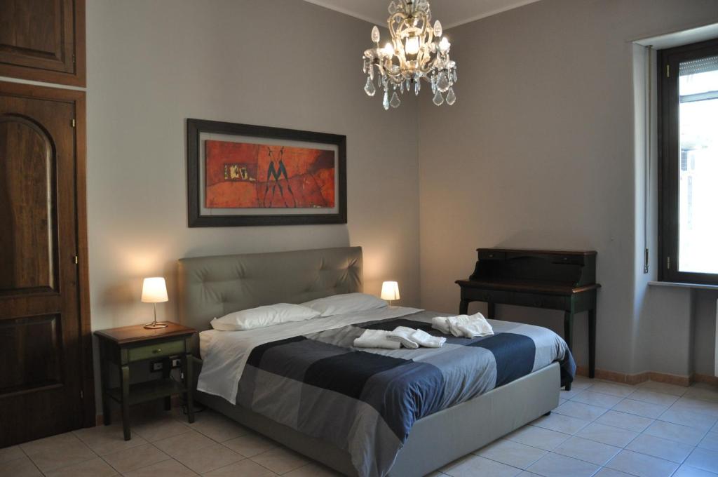 カターニアにあるPuccini apartmentのベッドルーム1室(シャンデリアとピアノ付きのベッド1台付)