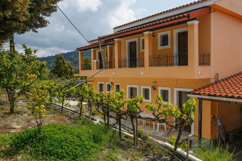 a house with vines in front of it at Andreas Apartments in Agios Georgios Pagon