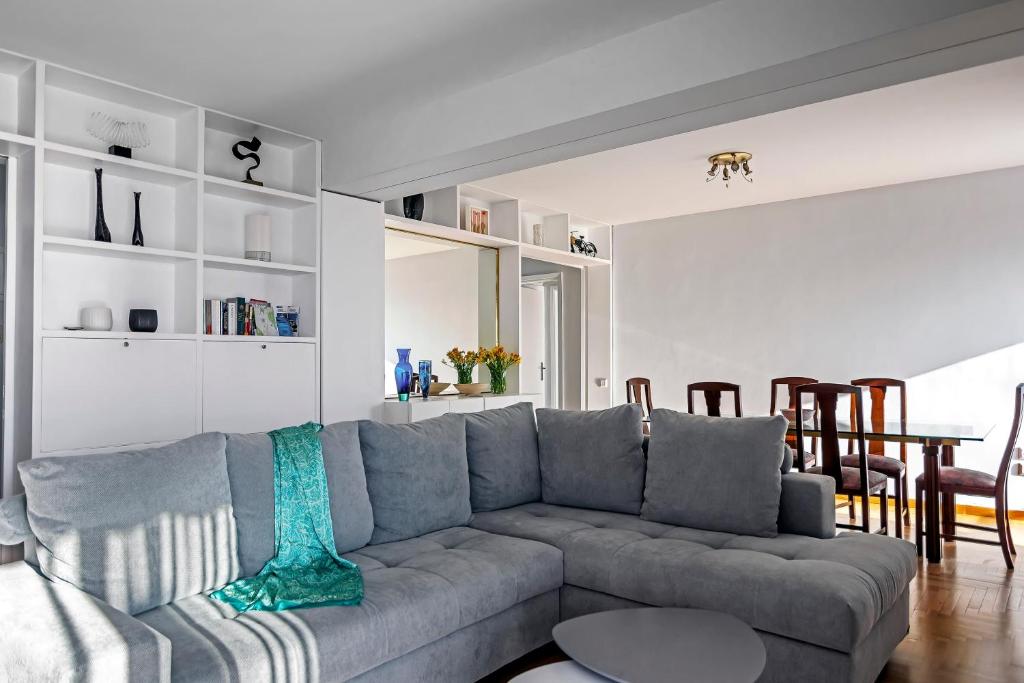 un soggiorno con divano grigio e tavolo di Amazing Seafront Apartment Athens Riviera ad Atene