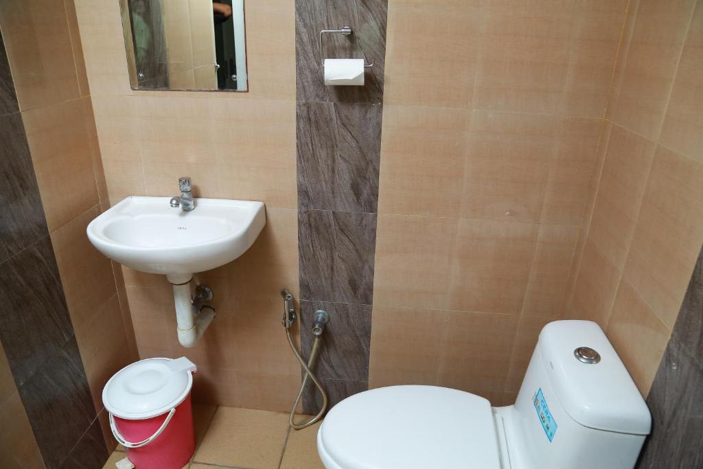 uma casa de banho com um WC e um lavatório em El Casa Homestay em Cochin