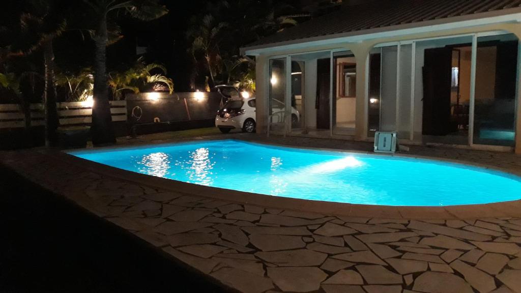 una piscina en un patio por la noche en Villa Cap Azur en Sainte-Clotilde