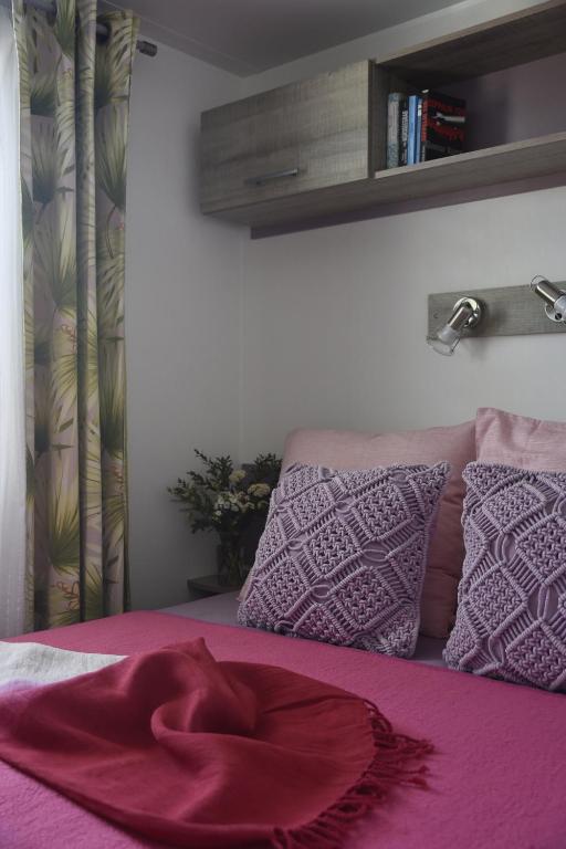 a bedroom with a bed with purple sheets and pillows at Sas Robrecht in Saint-Tropez