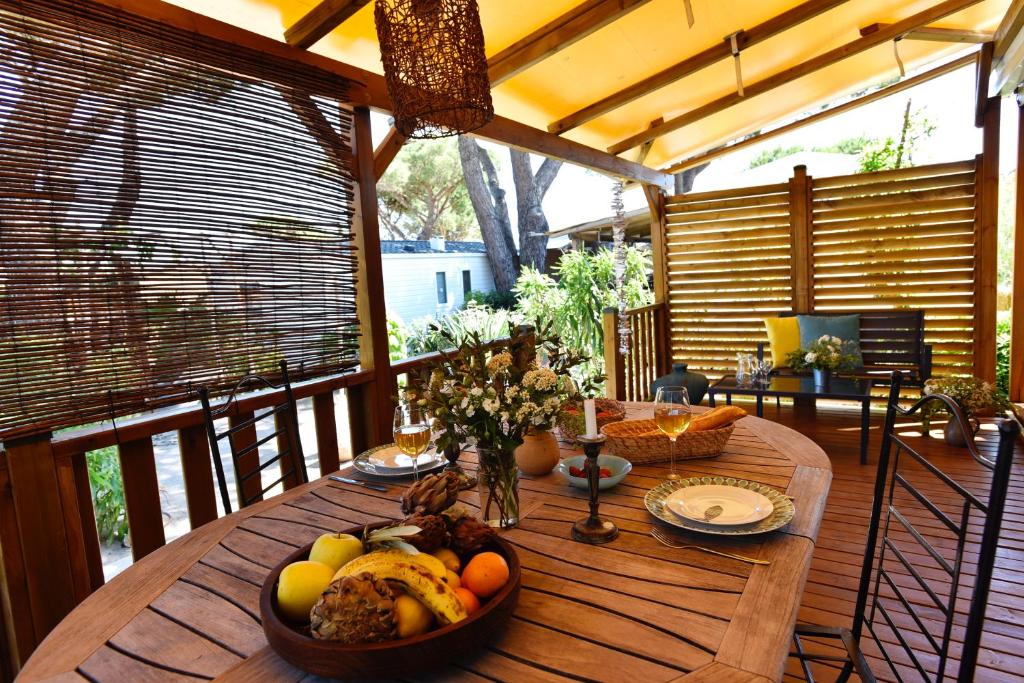 a wooden table with a bowl of fruit on a porch at Sas Robrecht in Saint-Tropez