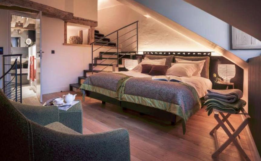 a bedroom with a bed and a staircase at Les Loges Annecy Vieille Ville in Annecy