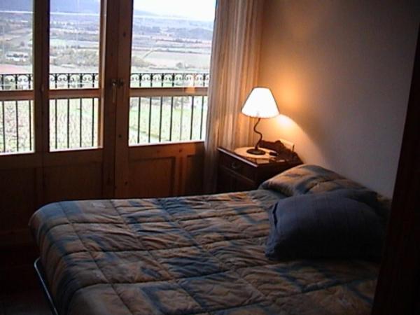 a bedroom with a bed and a lamp and a window at Tossal del Maig in Barbará
