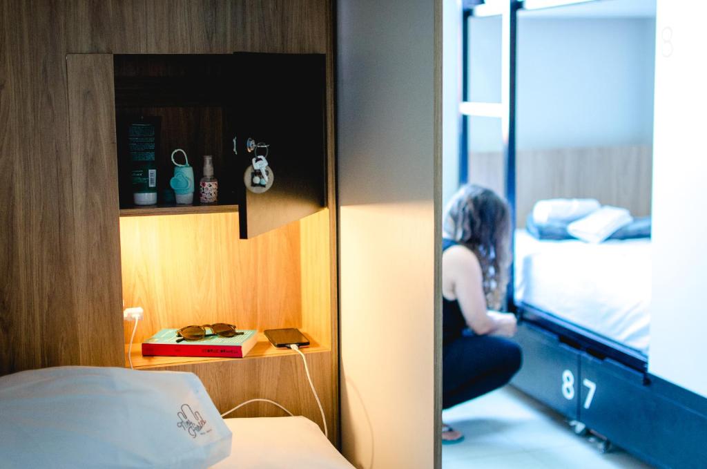 a woman sitting on a table in a hotel room at Meu Hostel in Maceió