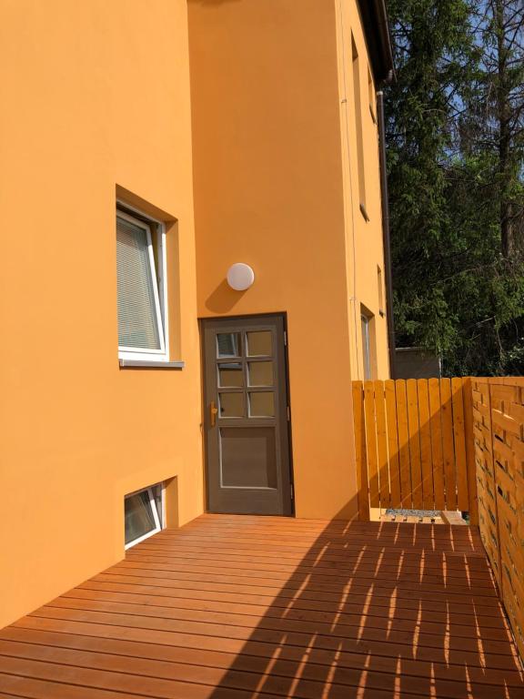 - une porte sur une maison avec une terrasse en bois dans l'établissement Apartmány LETO, à Frýdek-Místek