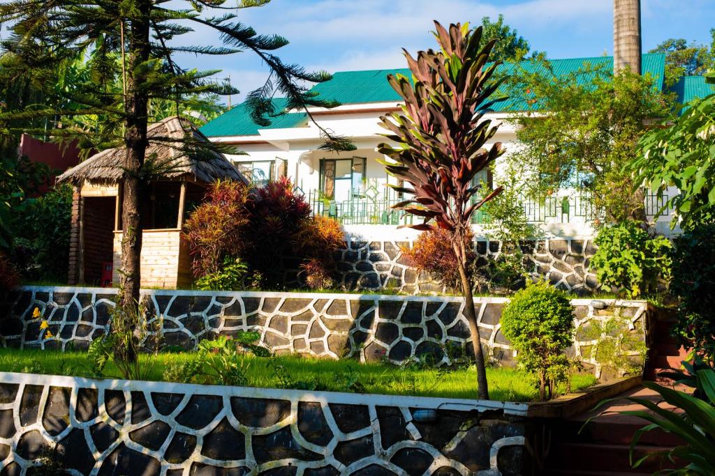 una casa con una pared de retención y una valla de piedra en Mambo Hideaway en Arusha