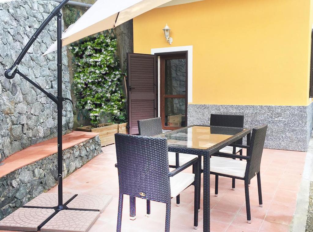a dining table with chairs and an umbrella on a patio at Casa Lin in Celle Ligure