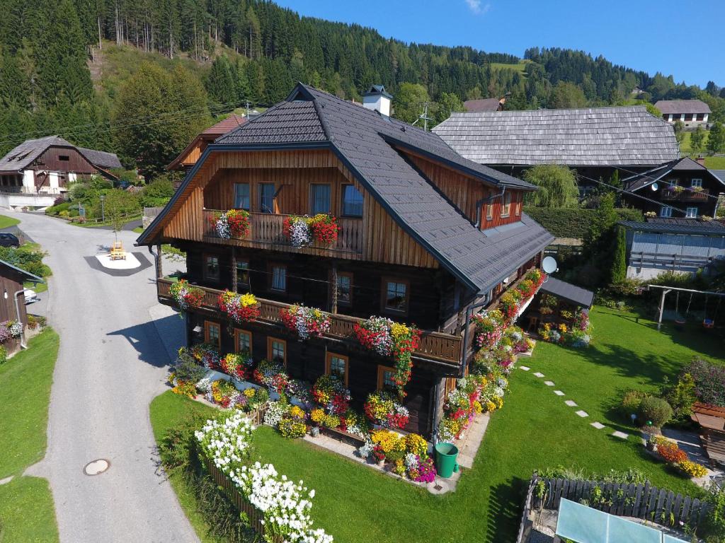 a house with flowers on the front of it at Bauernhof Unterkrug in Gnesau