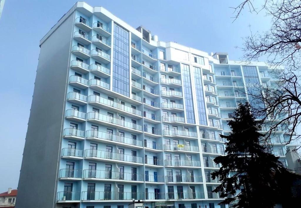 a large white building with a tree in front of it at SeaLine Apart-Hotel in Odesa