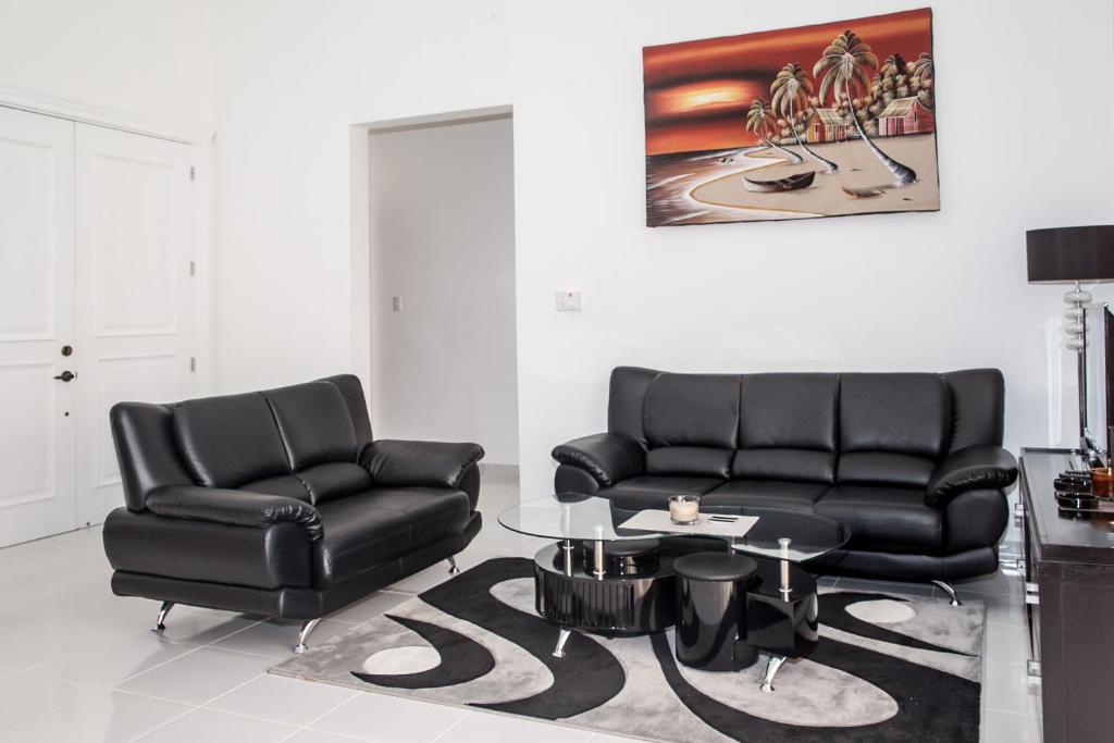 2 sillas de cuero negro y una mesa en la sala de estar en SOV 3 bedroom modern House, en Sosúa