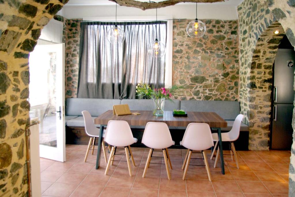 a dining room with a wooden table and pink chairs at Farmers House in Magarikárion