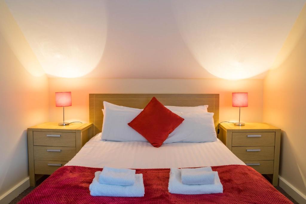 1 dormitorio con 1 cama con 2 mesitas de noche en The Courtyard Apartments, en Carrick on Shannon