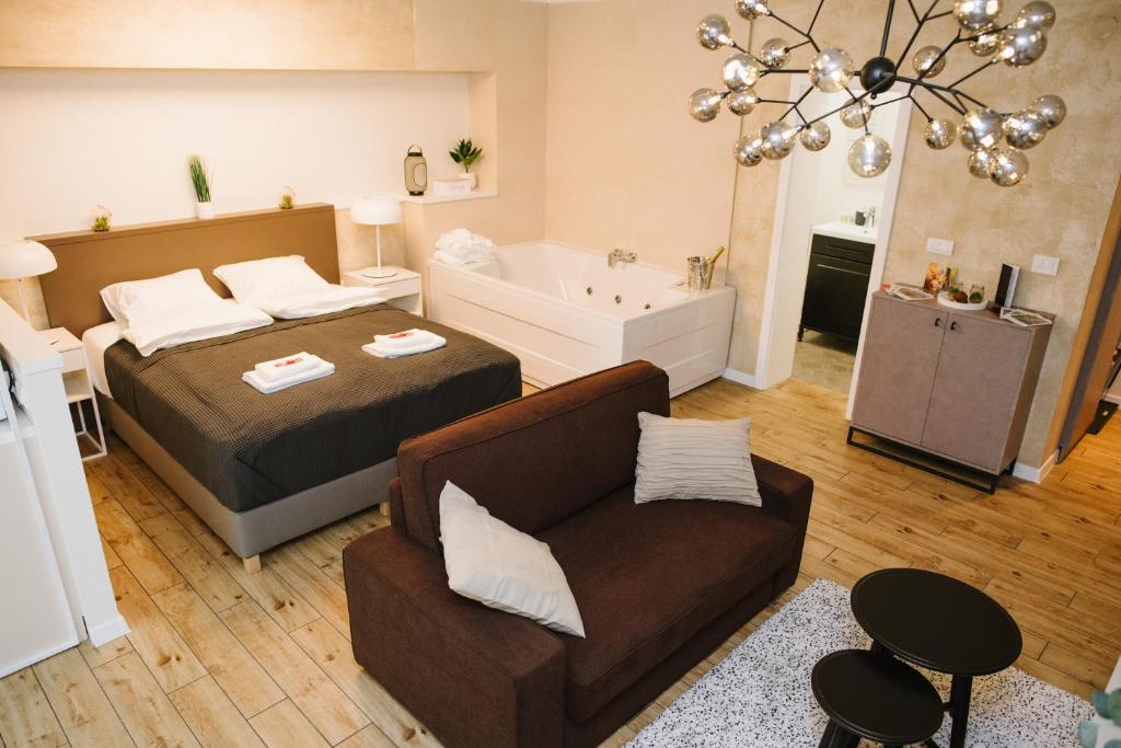 um quarto com uma cama, uma banheira e um sofá em Apartman Donner Centar III em Subotica