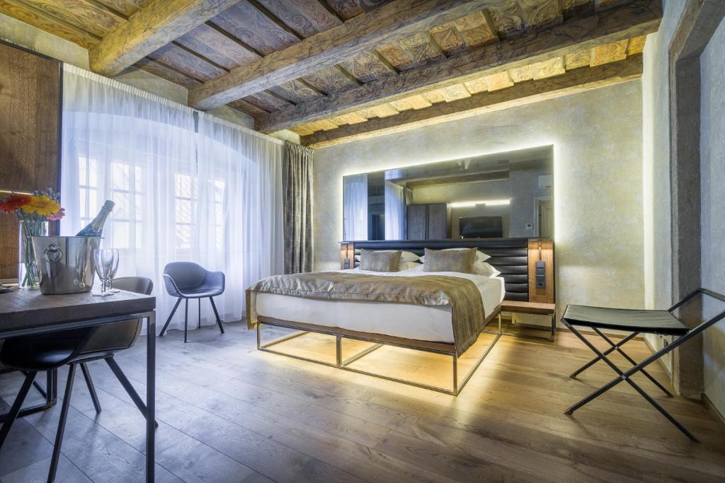 a room with a bed, a chair, and a table in it at Hotel Waldstein in Prague