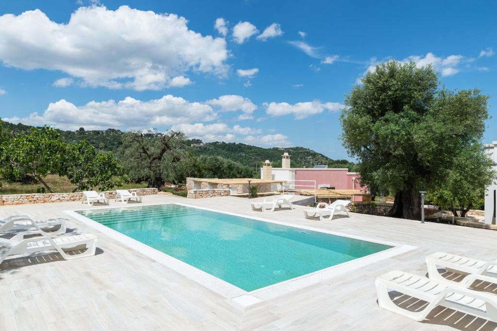 a swimming pool with lounge chairs and a villa at Villa Incanto con terrazza e piscina by Wonderful Italy in Ostuni