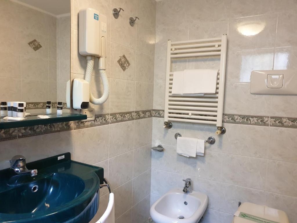 a bathroom with a blue sink and a toilet at Hotel Villa Cipro in Venice-Lido