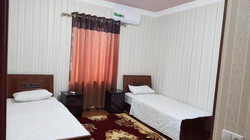 een kamer met 2 bedden en een rood gordijn bij B&B Giza Registan in Samarkand