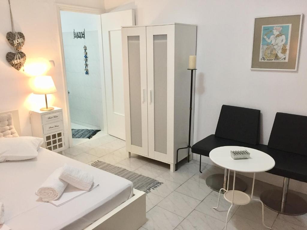 um quarto branco com uma cama, uma mesa e cadeiras em Kyano House em Limenas